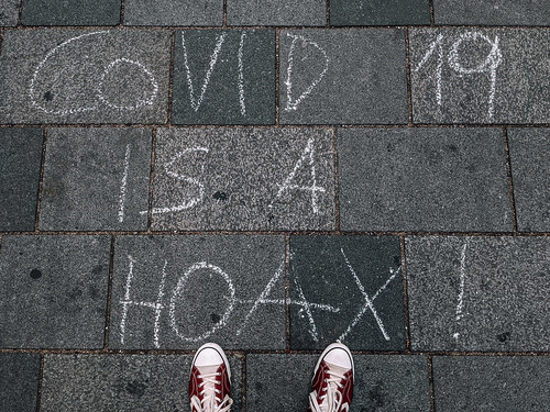 .Covid-19 is a hoax. written on the ground with a chalk, From FlickrPhotos