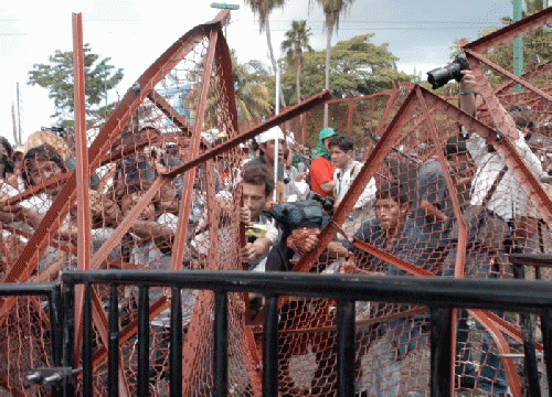 Demonstrators tear down security fence at WTO protest, Cancun, From ImagesAttr