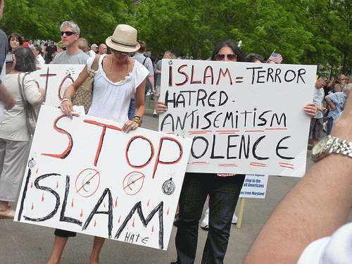 Jingoistic demonstration in Zucotti Park against proposed Islamic Cultural Center a few blocks from Ground Zero. Later, someone garlanded the proposed site with dirty shoes, raw porkchops, and cartoons of the Prophet., From ImagesAttr