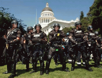 Heavily-armed police wearing riot gear form a protective cordon Heavily-armed police wearing riot gear form a protective cordon