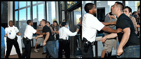 The beefy man shoves the guard, with Patrick Howley behind him