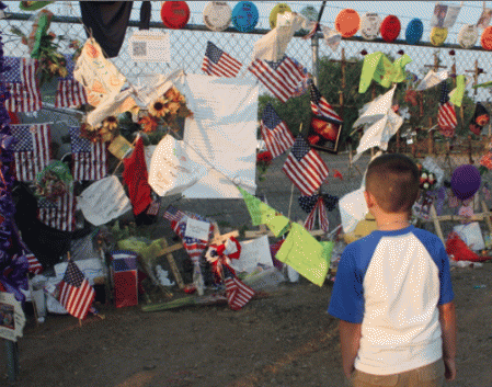 A young visitor contemplates the memorial and the prayer flags. A young visitor contemplates the memorial and the prayer flags.