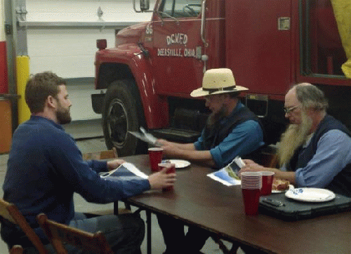 Austin Eudaly (L), an executive with Flatiron Energy Partners, talks with members of the Ohio Amish community at the Deersville, Ohio, Volunteer Fire Department on December 10, 2013., From ImagesAttr