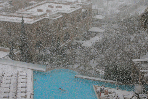 A snowstorm around Jerusalem disrupted travel and electricity on Friday but did not deter a swimmer at the David Citadel Hotel.