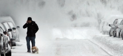 A man and his dog contend with blowing snow in Brooklyn following a snow storm that left up to 8 inches of snow in New York, United States.