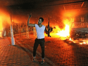An armed man waves his rifle as buildings and cars are engulfed in flames after being set on fire inside the U.S. consulate compound in Benghazi late on Sept. 11, 2012., From ImagesAttr