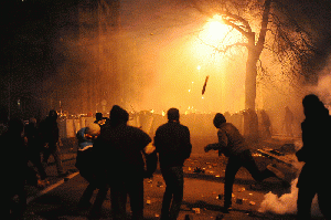 Protesters throwing pieces of paving and metal tubes at riot police during clashes at Ukraine., From ImagesAttr