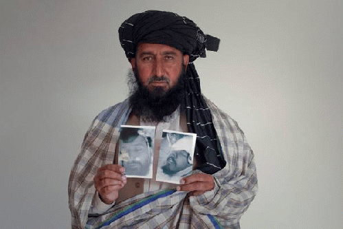 Kareem Khan holding photos of son and brother killed in drone strikes, From ImagesAttr