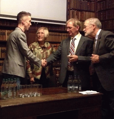 Aaron Kirkhouse (left), a childhood friend of Chelsea Manning, accepting the Sam Adams Award for Integrity in Intelligence on her behalf. Also in photo: US Army Col. Ann Wright (ret.), Craig Murray, and former CIA analyst Ray McGovern., From ImagesAttr