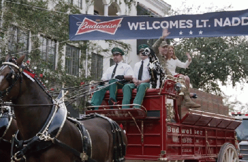 Lieutenant Chuck Nadd rides in a wagon pulled by Budweiser-sponsored Clydesdale horses in the companyâ€™s â€œA Hero's Welcomeâ€ Super Bowl ad. (Youtube).