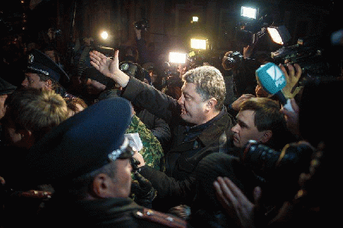 A crowd of angry pro-Russian demonstrators, as well as police and media, accompany Ukrainian MP Petro Poroshenko as he walks through the streets of the Crimean city of Simferopol., From ImagesAttr