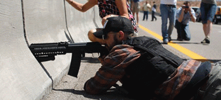 A protester aims his weapon from a bridge next to the Bureau of Land Management's base camp., From ImagesAttr