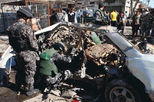Iraqi policemen examine the remains of a car bomb in Baghdad's Sadr City, From ImagesAttr