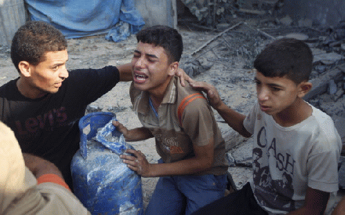 Palestinian relatives mourn for victims of the Duheir family, near the rubble of their home, after it was destroyed by an Israeli air strike in Rafah on July 29, 2014, in the southern of Gaza strip., From ImagesAttr