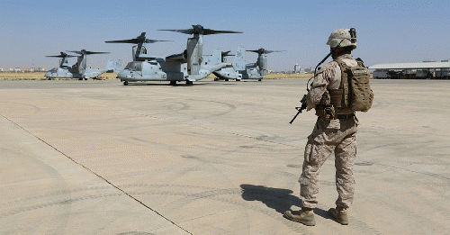 A U.S. Marine stands in front of Osprey aircraft on Aug. 12, 2014., From ImagesAttr