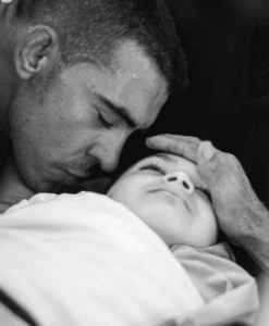 A relative holding the body of Khalil Muhammad al-Anatim before he is lowered into the ground, From ImagesAttr