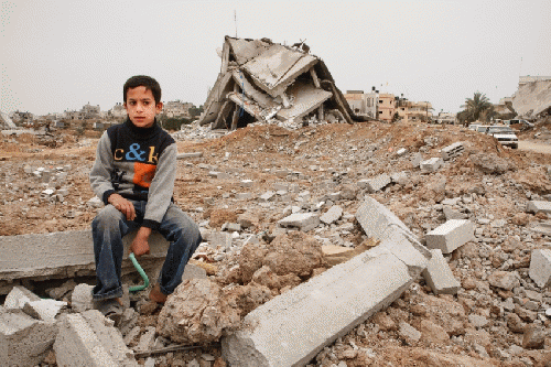 A Palestinian child in Gaza sits atop rubble after Israel's Operation Cast Lead in 2009., From ImagesAttr