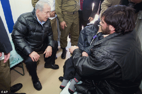 Israeli Prime Minister Benjamin Netanyahu speaks to a wounded Syrian rebel as he visits a military hospital located in the occupied Syrian Golan Heights near the border with Syria on Tuesday, Feb. 18, 2014, From ImagesAttr