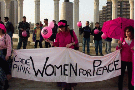 Jodie Evans of Codepink in Baghdad holding banner with kids Feb 4th 2003, From ImagesAttr