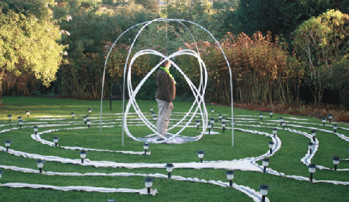 Kathy Ruyts in a Genesa crystal in the center of a labyrinth made by Ansula Press. The labyrinth is made from fabric strips and solar lights.