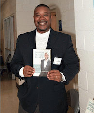 Drayton holding a cover of his new book