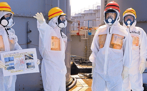 Japan's Prime Minister Shinzo Abe (second right) is briefed about tanks containing radioactive water by Fukushima nuclear power plant chief Akira Ono. Photo: Reuters.