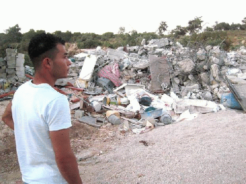 Relatives of Tareq Khatib survey the ruins of his home on the edge of the Israeli town of Kafr Kana, destroyed by Israeli officials on June 15, From ImagesAttr