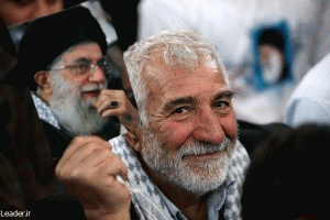 An Iranian man holding a photo of Supreme Leader Ali Khamenei.