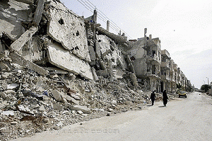 Syrian women walk past destruction in the Bab Amro neighbourhood of Homs, From ImagesAttr
