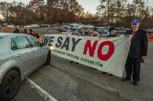 Bishop George Packard, right, holds a banner with fellow protesters as they block an entrance to a gas pipeline construction operation in Montrose, N.Y. The banner reads, 