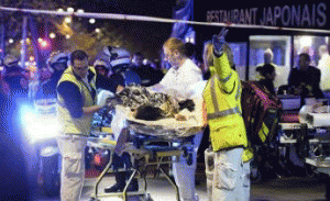 Rescuers evacuate an injured person near the Bataclan concert hall in central Paris, early on Nov. 14, From ImagesAttr