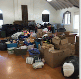 donations awaiting volunteer sorting and packing on Pack & Delivery Day during  October, Domestic Violence Awareness Month