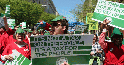 Demonstrators hold signs in support of a financial transactions tax (FTT), also known as a Robin Hood tax.