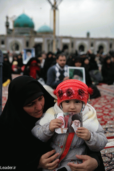 An Iranian child holding a photo of Iran's Supreme Leader Ali Khamenei at one of his public appearances., From ImagesAttr