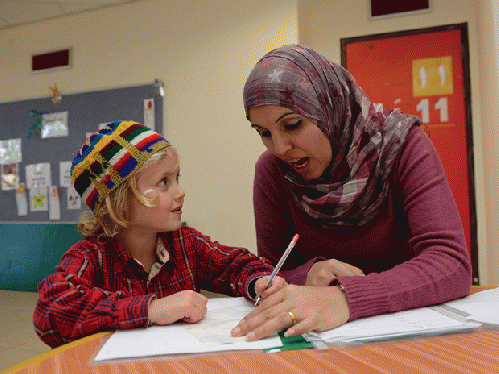 A young Jewish Israeli girl is taught Arabic by her Israeli Arab teacher in a bilingual school