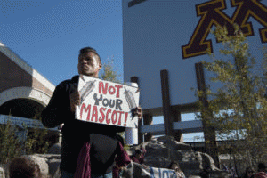 A protestor holds a sign against the Washington football team's name at a rally in Minneapolis, Minnesota on November 2, 2014