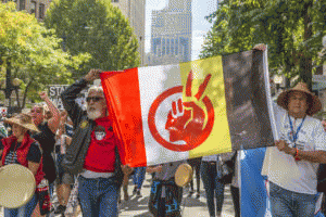 Activists carry the American Indian Movement flag at a protest against the Dakota Access Pipeline. Seatte, WA; September 16, 2016.