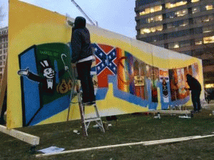 Artists work on a sign that reads 