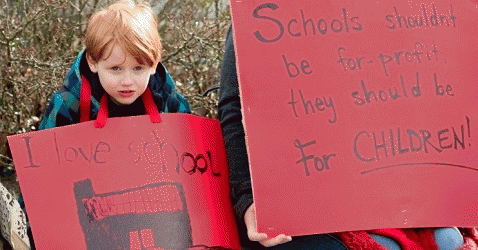 A young demonstrator holds a sign protesting Betsy Devos as Education Secretary., From ImagesAttr