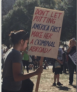 this signs reads: Don't let putting America first make her a criminal abroad!