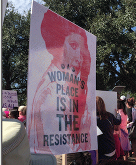 this sign says: A Woman's Place is in the Resistance [superimposed on image of Princess Leia]