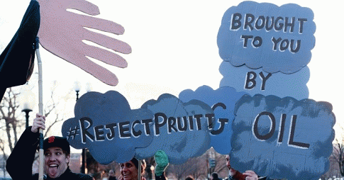 Demonstrators hold signs at a rally to stop the appointment of Scott Pruitt for the EPA., From ImagesAttr