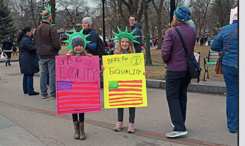 Two young feminists. Signs read: 