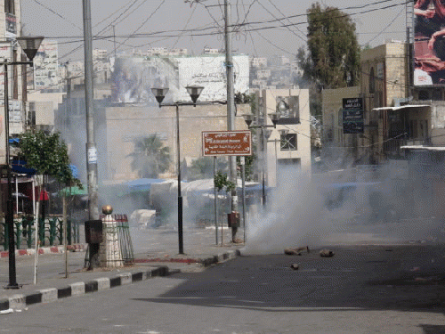 Street leading up from vegetable market filling up with tear gas