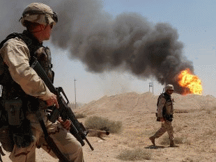 A U.S. soldier stands guard duty near a burning oil well in the Rumaila oil field in 2003., From ImagesAttr