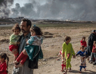 A family displaced by fighting in the village of Shore, 25 kilometers south of Mosul, Iraq, walk towards an army checkpoint on the outskirts of Qayyarah, From ImagesAttr