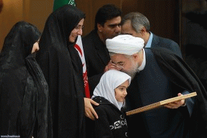 Iran's President Hassan Rouhani celebrates the completion of an interim deal on Iran's nuclear program on Nov. 24, 2013, by kissing the head of the daughter of an assassinated Iranian nuclear engineer.