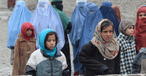 Girls and mothers, waiting for their duvets, in Kabul.