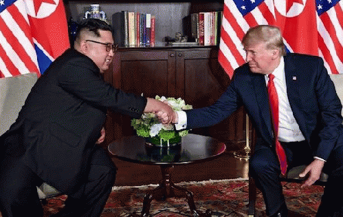 President Trump and North Korean President Kim Jong Un shake hands in summit room, June 12, 2018.