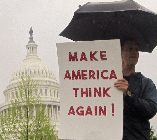 A man holds a sign reading 